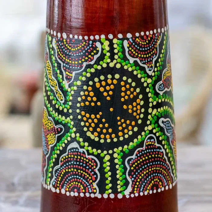 Djembê decorativo e funcional confeccionado manualmente em Bali, com detalhes pintados à mão e acabamento natural que valoriza a textura da madeira. 