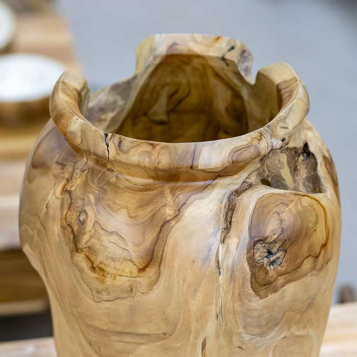 Detalhe do vaso decorativo em raiz de madeira teca de Bali, peça artesanal com textura natural e veios únicos, destacando a beleza da madeira tropical.