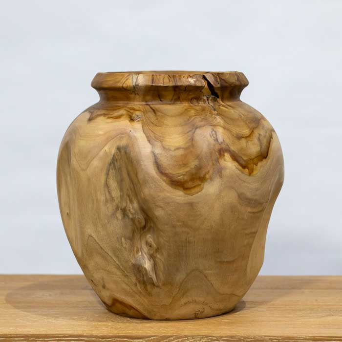 Detalhe do vaso de madeira teca artesanal com superfície lisa e veios naturais, peça exclusiva feita em Bali que valoriza a textura e a cor da madeira tropical.