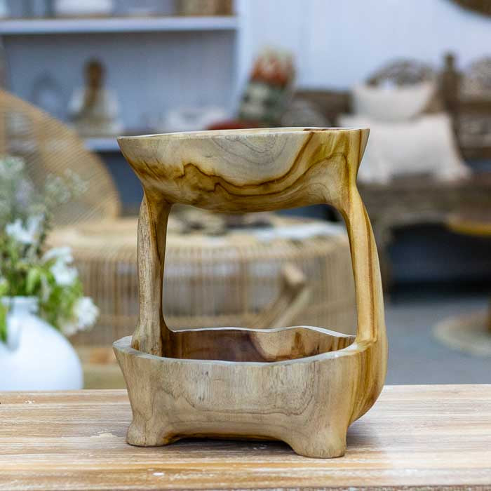 Objeto decorativo artesanal de Bali em madeira maciça, fruteira dupla com formas curvas e acabamento natural que destaca os veios e a textura da madeira.