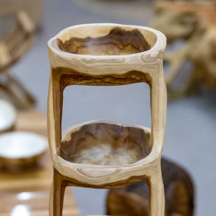 Escultura funcional em madeira maciça com quatro compartimentos, fruteira artesanal de Bali com design fluido e textura orgânica.