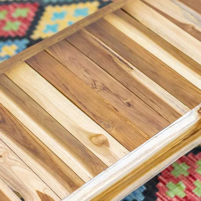 Calçadeira de madeira teca feito manualmente em Bali com laterais curvas e base cruzada, obra que combina conforto, estética e tradição artesanal.