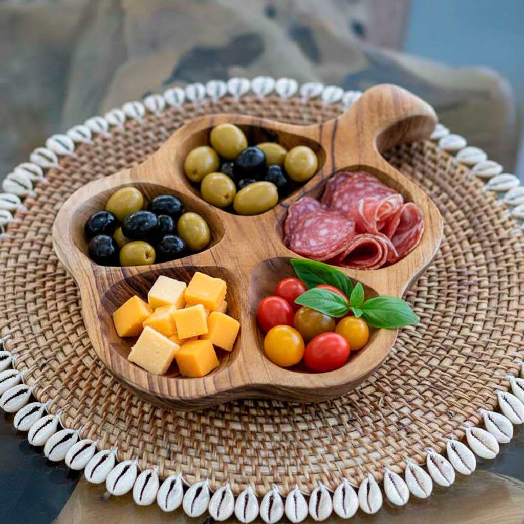 Petisqueira artesanal feita à mão em madeira teca natural de Bali, com formato de flor e quatro divisórias que valorizam o design orgânico e funcional.