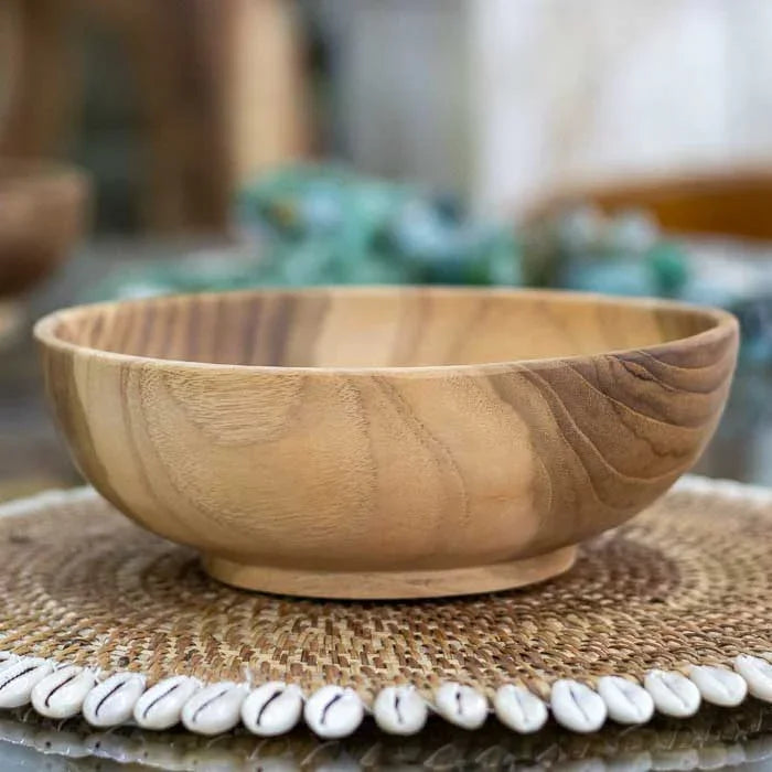 Tigela artesanal em madeira teca com textura suave e tonalidades naturais, peça funcional e decorativa inspirada no design balinês. 