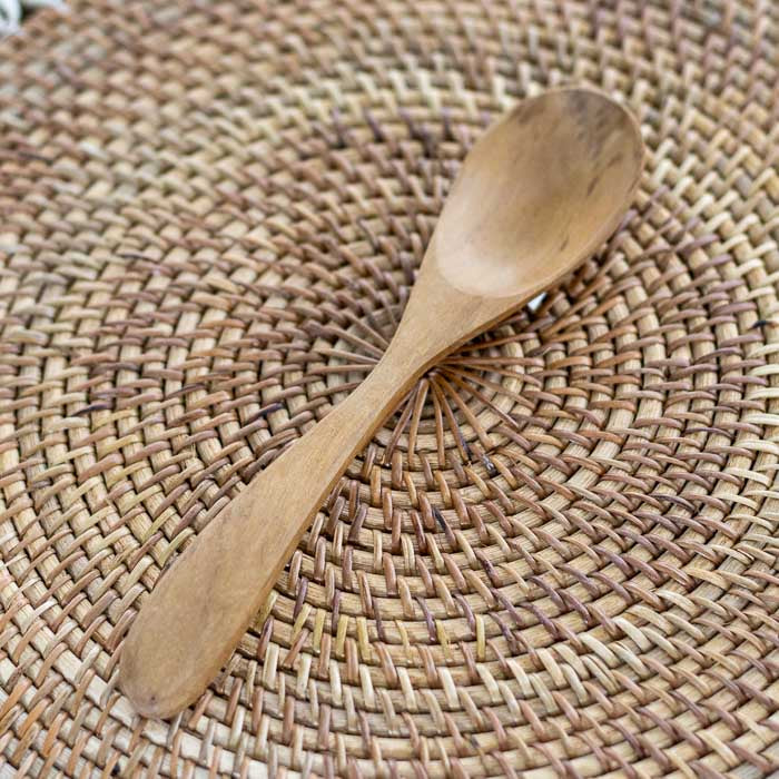 Colher longa de teca produzida manualmente em Bali com superfície suave e veios naturais indicada para cozinhar sem danificar panelas.