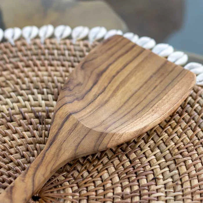 Utensílio artesanal em madeira teca produzido em Bali com superfície lisa, cabo reto e veios naturais perfeito para uso culinário diário.