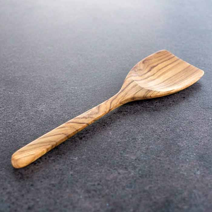 Espátula de teca maciça originária de Bali com design natural e estrutura resistente indicada para virar, refogar e servir pratos diversos.