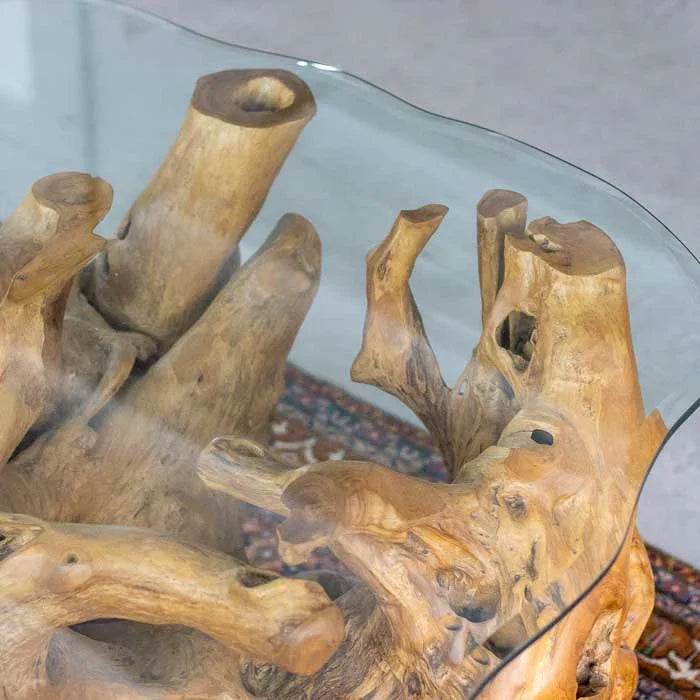 Mesa rústica de Bali com base escavada em raiz de teca e vidro temperado de bordas orgânicas que valorizam o desenho natural da madeira.