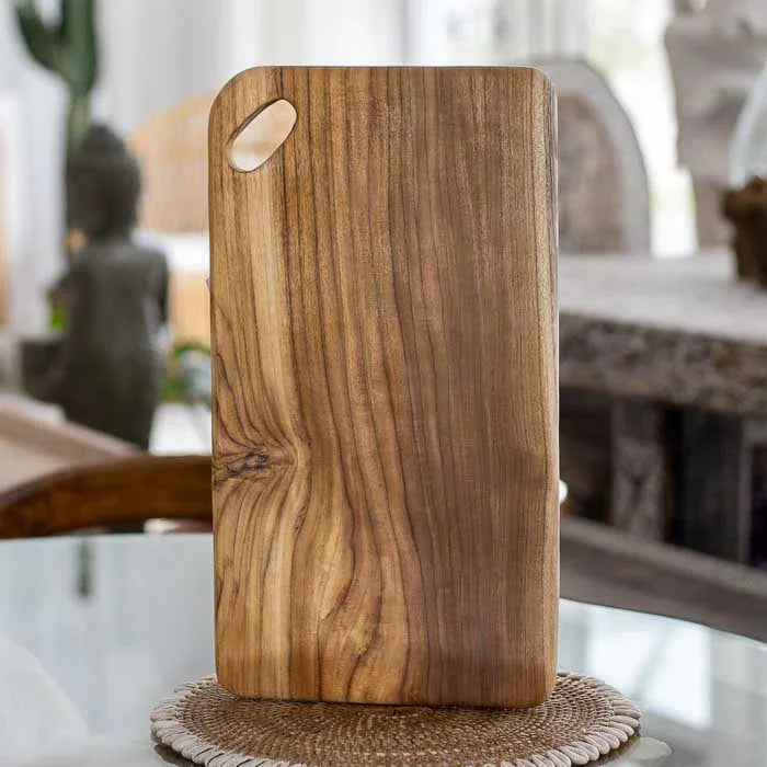 Utensílio artesanal de madeira teca com formato retangular e alça vazada, perfeito para cortar alimentos e complementar ambientes com estilo natural
