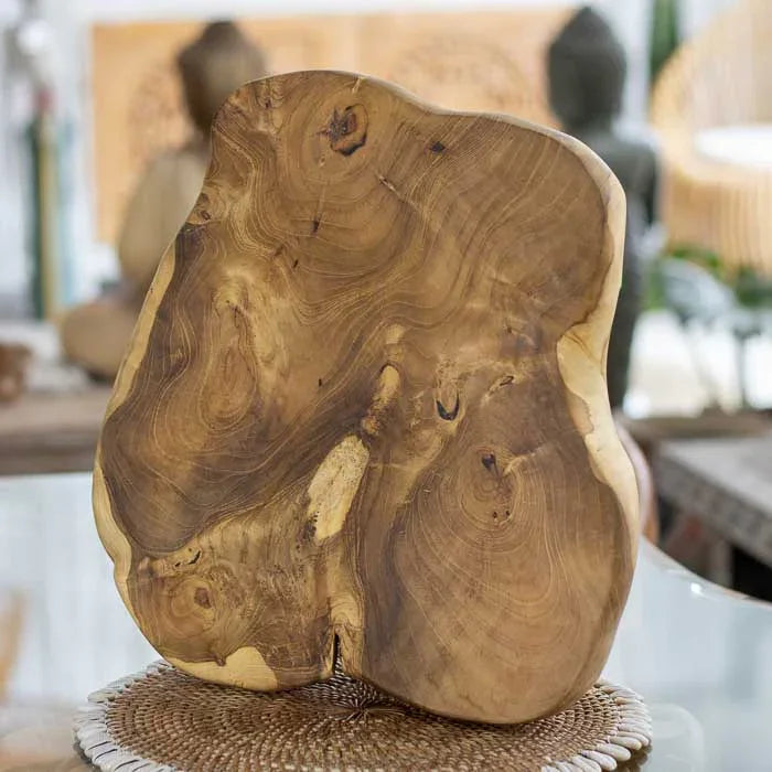 Peça artesanal em raiz de madeira teca de Bali com formato orgânico e superfície polida utilizada como tábua de corte e servir.