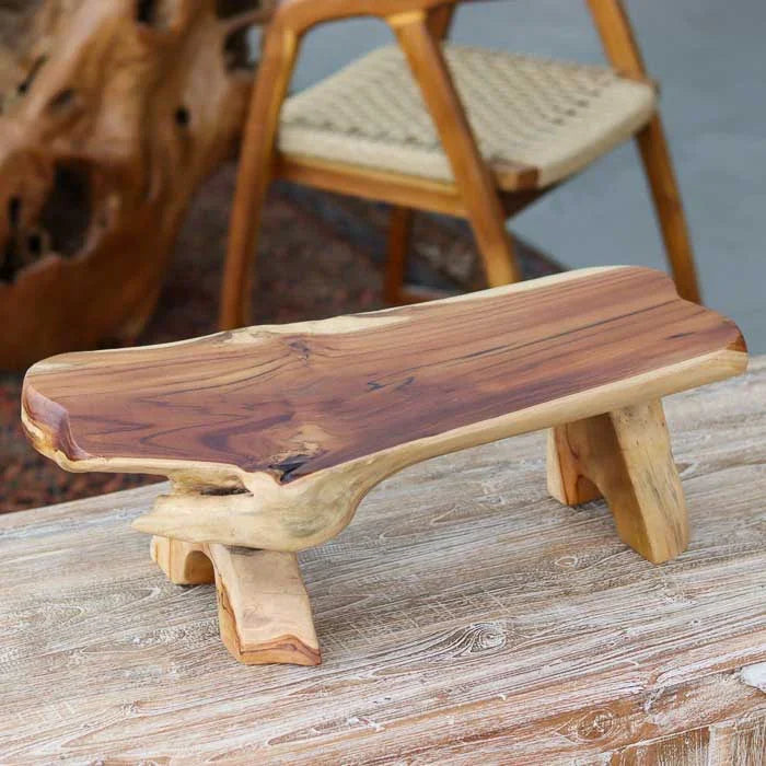 Mesa baixa de madeira teca artesanal de Bali com tampo orgânico mesclado e base maciça, ideal para apoiar objetos decorativos.