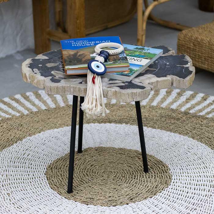 Mesa rústica petrificada com tampo irregular e pés de ferro criada em Bali para ambientes com estética natural e autêntica.