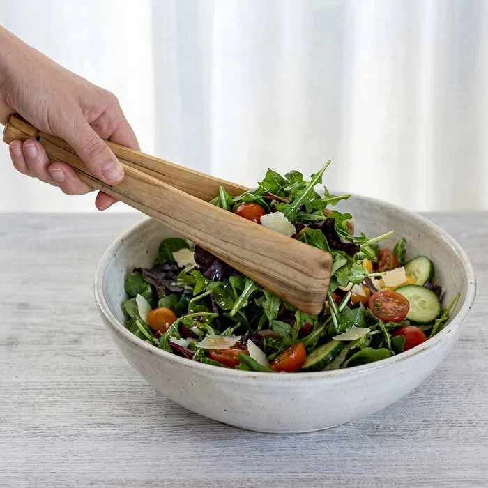 Utensílio de servir em madeira com design articulado e acabamento artesanal.