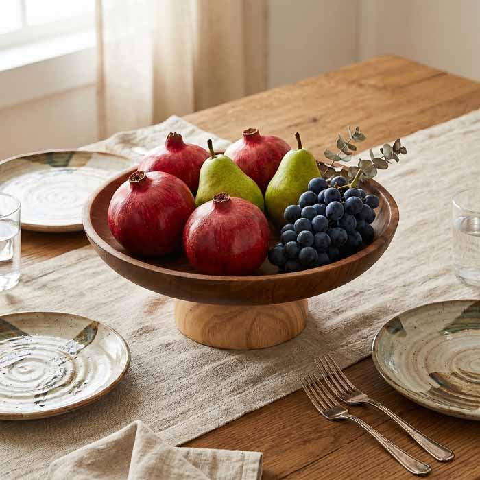Fruteira de madeira artesanal para mesa de jantar com estética contemporânea.