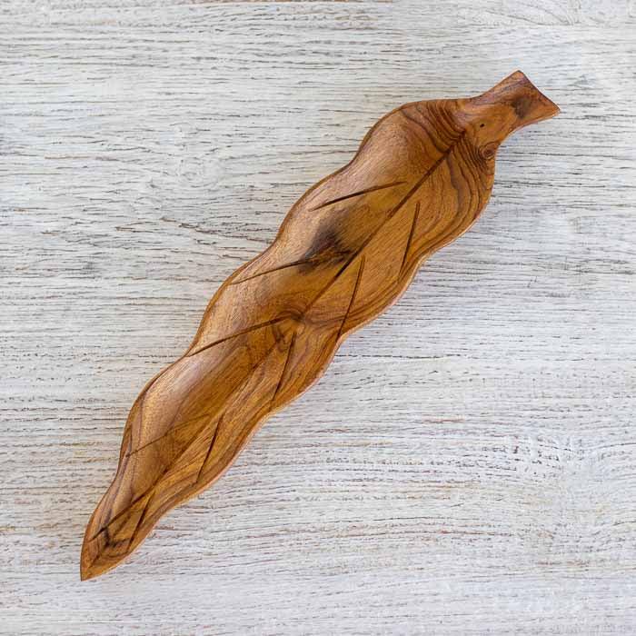 Incensário artesanal em madeira teca com design de folha esculpido à mão.