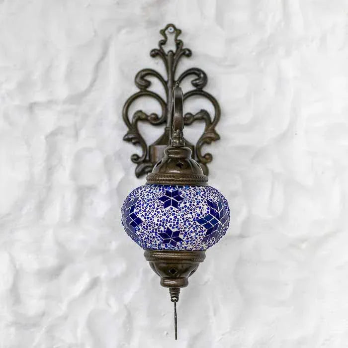 Detalhe da cúpula de vidro artesanal com mosaico azul e contas brancas em luminária de estilo oriental.