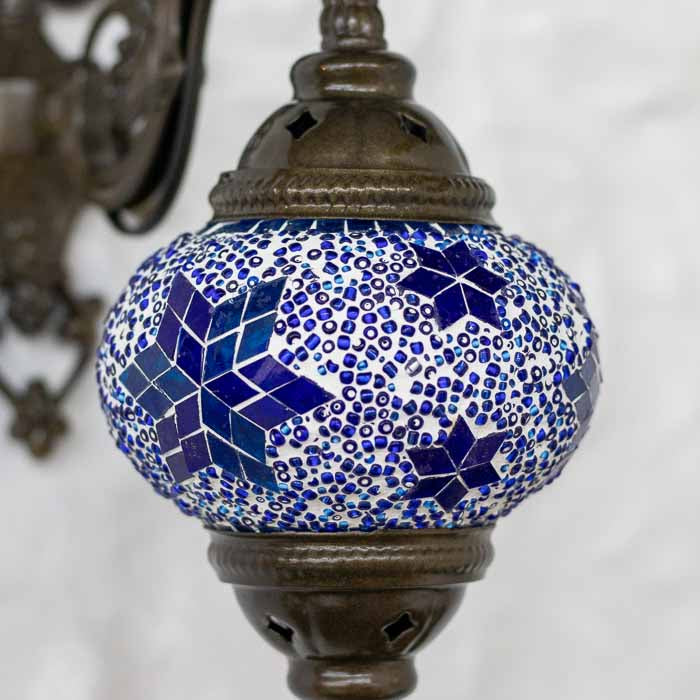 Luminária turca artesanal de 25cm evidenciando o contraste entre o acabamento bronze e o mosaico azul vibrante.