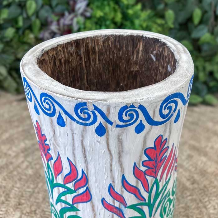 Detalhe de vaso decorativo com padrões de espirais e flores coloridas, uma peça que celebra o artesanato sustentável. 