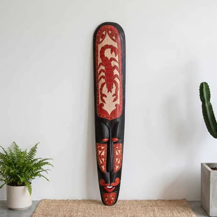Máscara decorativa tribal em madeira escura com escorpião. 