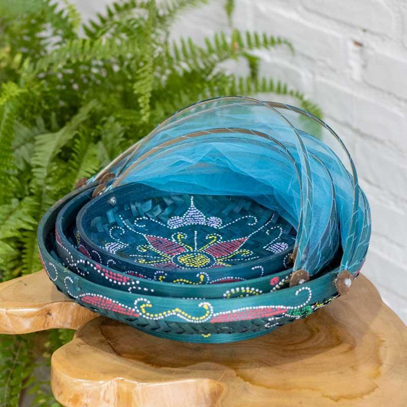 Cesta artesanal balinesa sendo aberta para servir quitutes em um brunch ao ar livre, destacando o uso funcional e decorativo. 