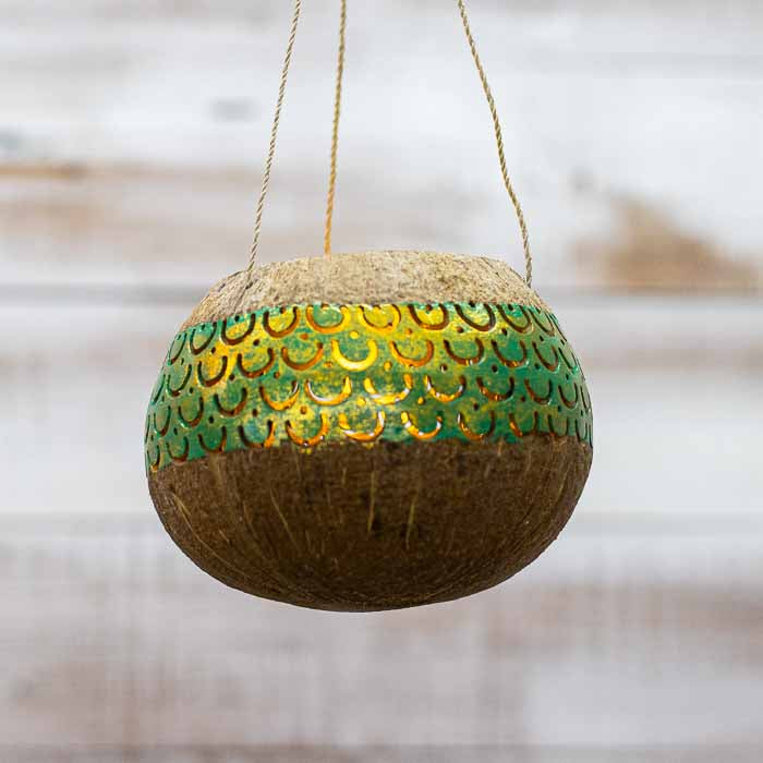 Detalhe da curvatura natural da casca do coco em lanterna suspensa artesanal. 
