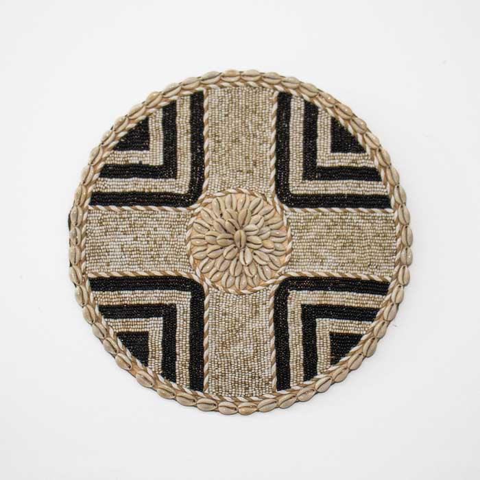 Objeto decorativo com conchas naturais e formas circulares, inspirado na cultura balinesa e feito à mão. 