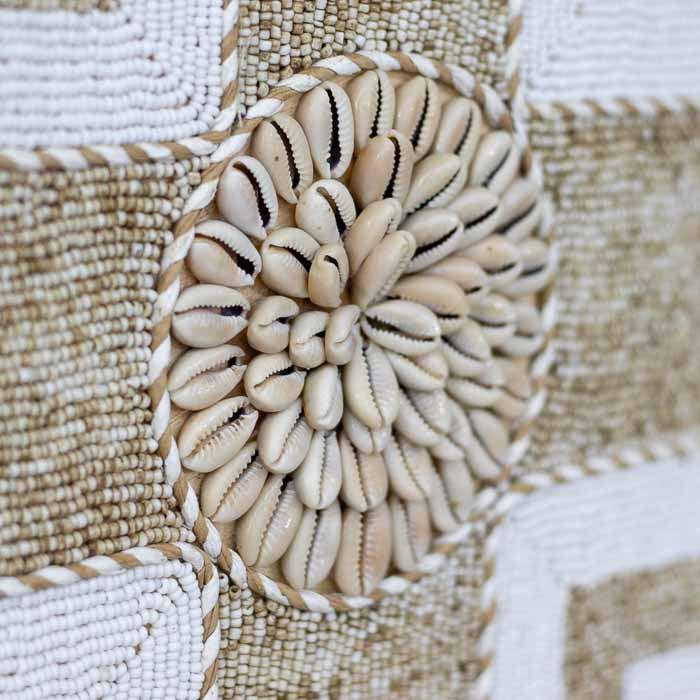 Objeto decorativo com conchas brancas e formas circulares, inspirado na estética balinesa. 