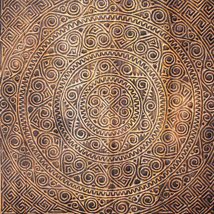 Painel entalhado de Bali com símbolos tribais e acabamento rústico.