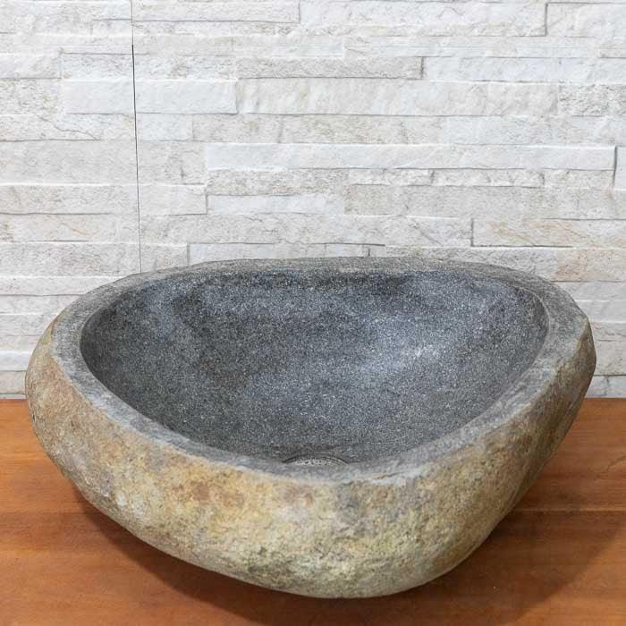 Cuba esculpida em pedra natural, feita à mão em Bali com formas orgânicas e acabamento rústico. 