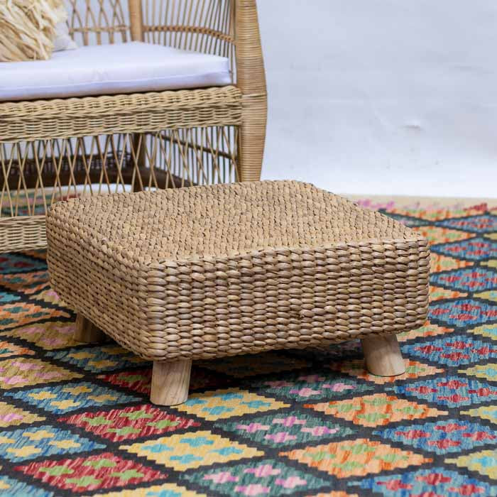 Puff quadrado artesanal com revestimento em fibras naturais trançadas.