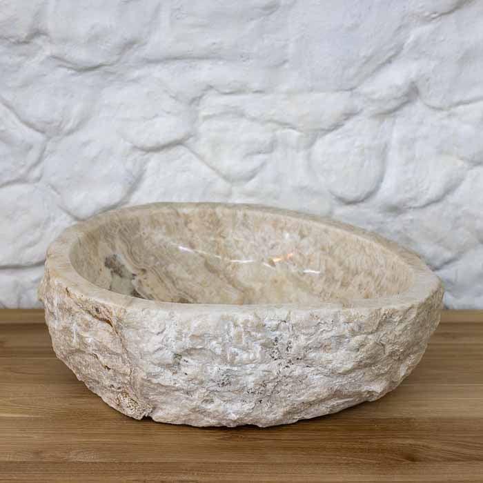 Cuba de pia esculpida manualmente, evidenciando os veios únicos da pedra. 