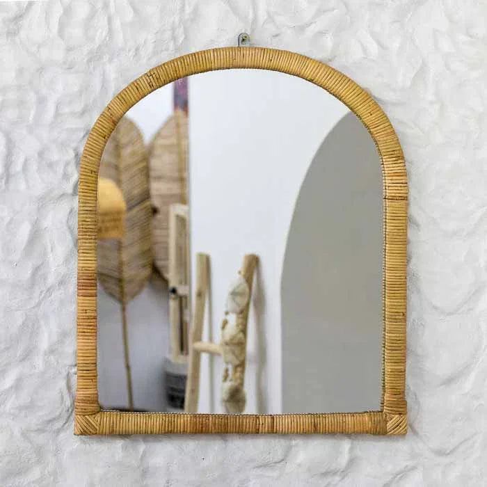 Espelho de parede em formato de arco com moldura detalhada em tramas horizontais de rattan natural.
