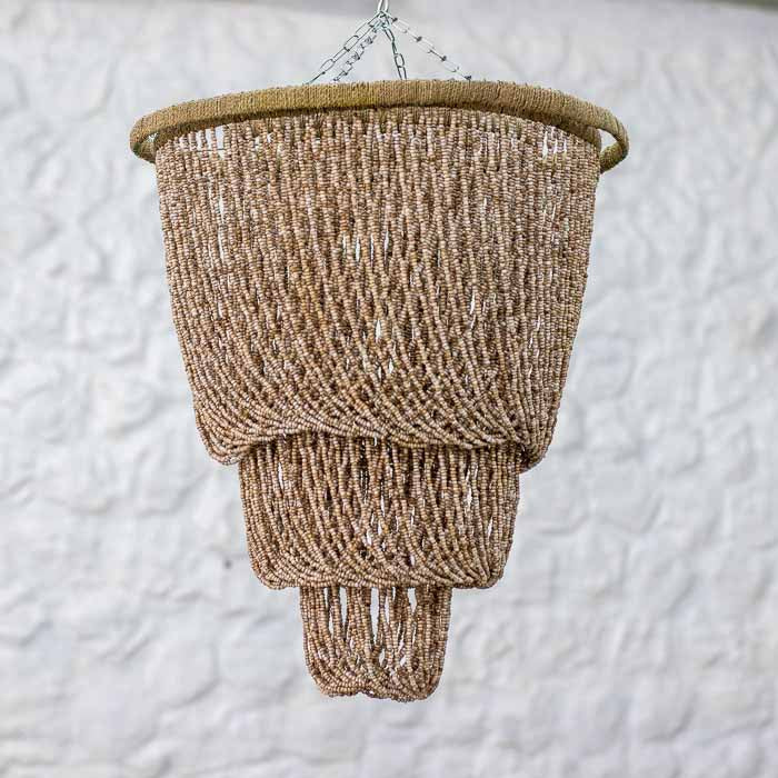 Lustre pendente artesanal de três camadas em miçangas naturais de Bali suspenso por corrente metálica.