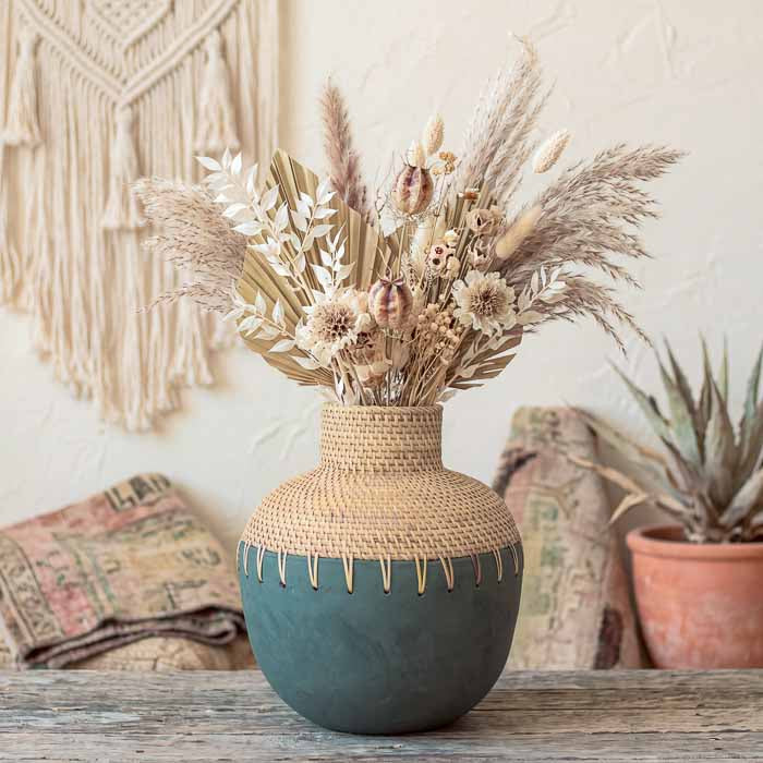 Vaso de terracota arredondado artesanal com acabamento fosco e cúpula afunilada em fibra natural de rattan.