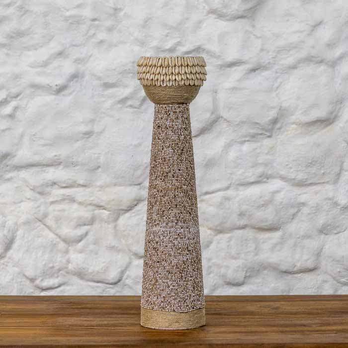 Suporte para velas feito à mão em Bali com revestimento artesanal de textura em tom de areia e borda de búzios naturais.