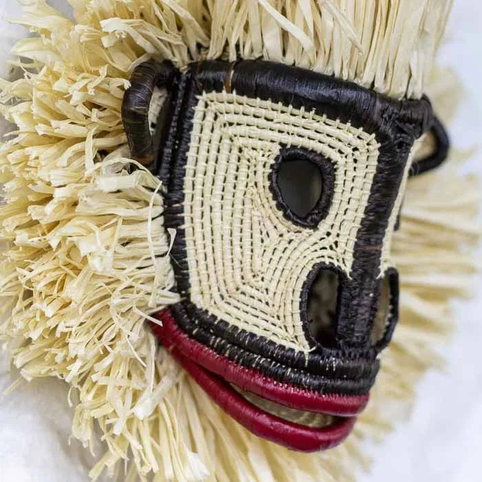 Objeto tribal de colecionismo étnico destacando a técnica de tecelagem manual em máscara de animal. 