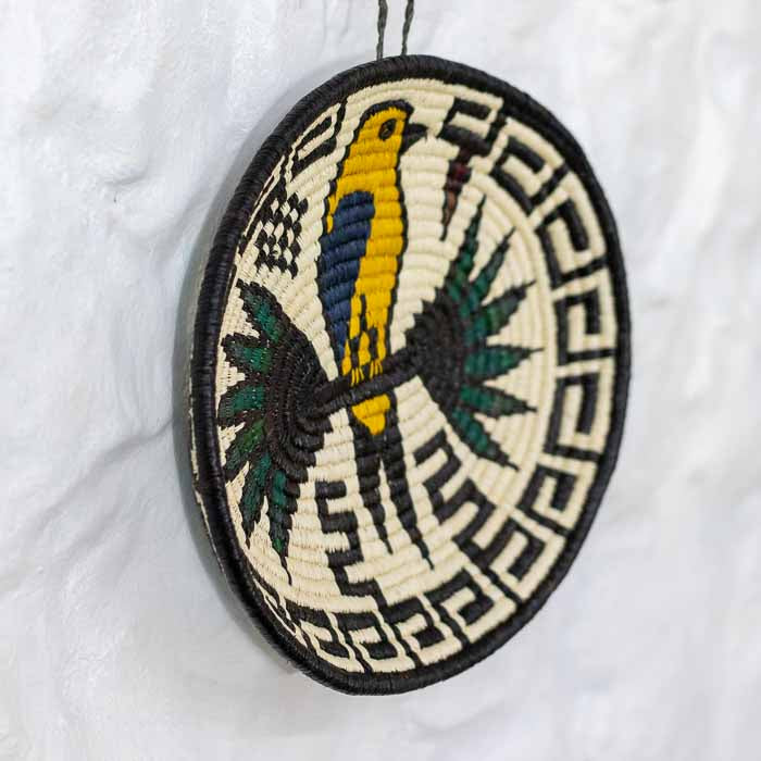 Objeto de colecionismo de arte indígena com desenhos tribais simétricos tecidos em fibra sustentável. 