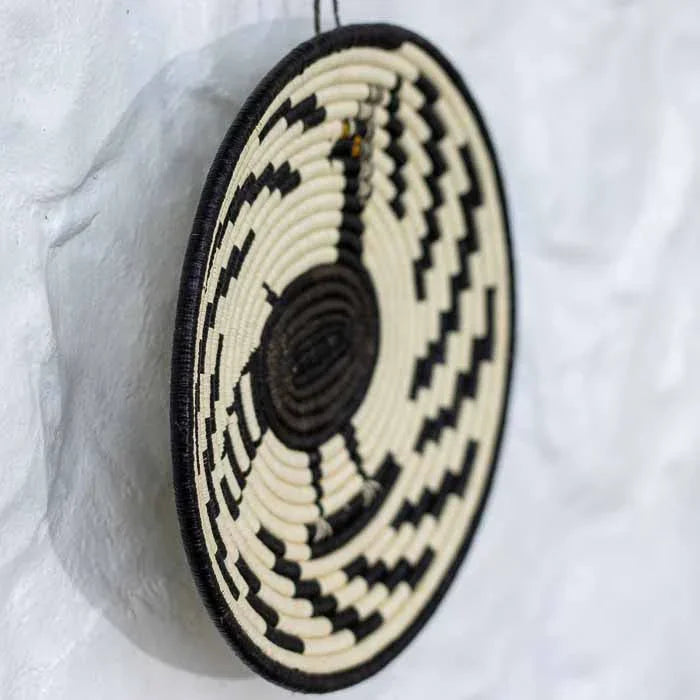 Detalhe da trama fechada e minuciosa de cesta de parede artesanal feita com folhas de palmeira do Panamá. 