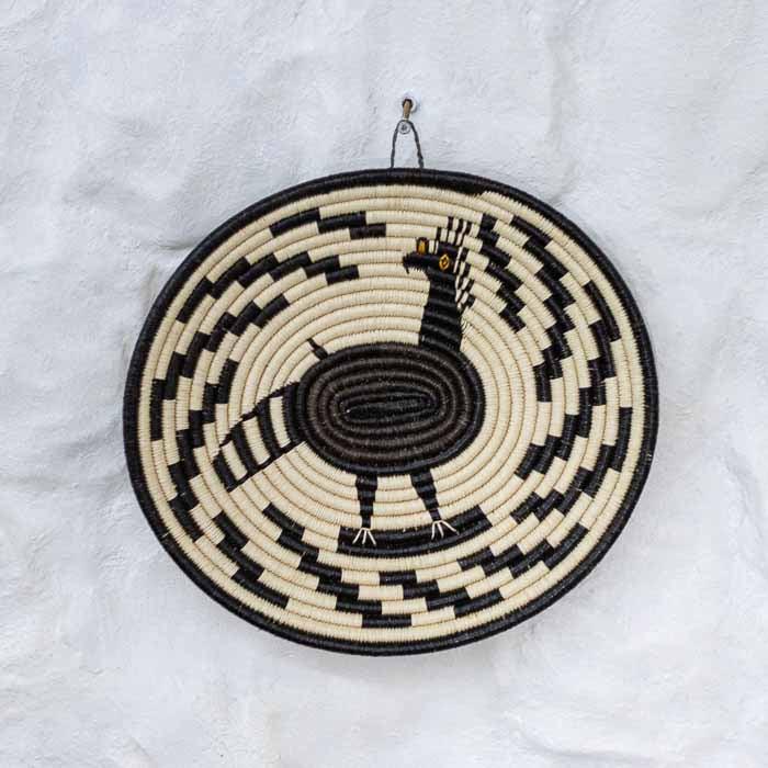 Prato de cestaria indígena tecido à mão em fibra de chunga com grafismos geométricos da etnia Emberá-Wounaan. 