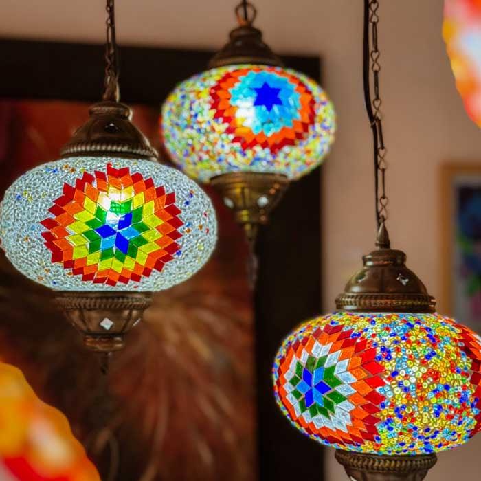 Iluminação decorativa exótica com luminária turca de teto instalada sob forro de palha, destacando o estilo rústico. 