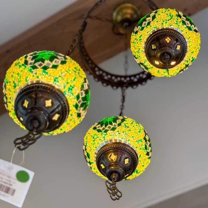 Lustre turco de 3 braços exibindo os padrões geométricos dos mosaicos manuais em tons de vermelho, azul e dourado. 