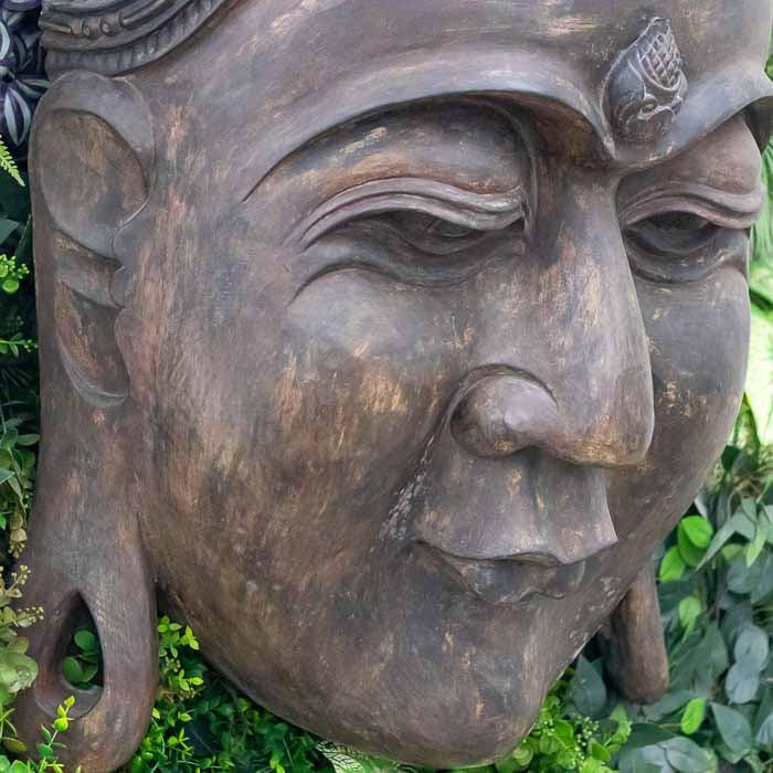 Estátua de parede do semblante de Buda com expressão meditativa e serena esculpida em Bali.