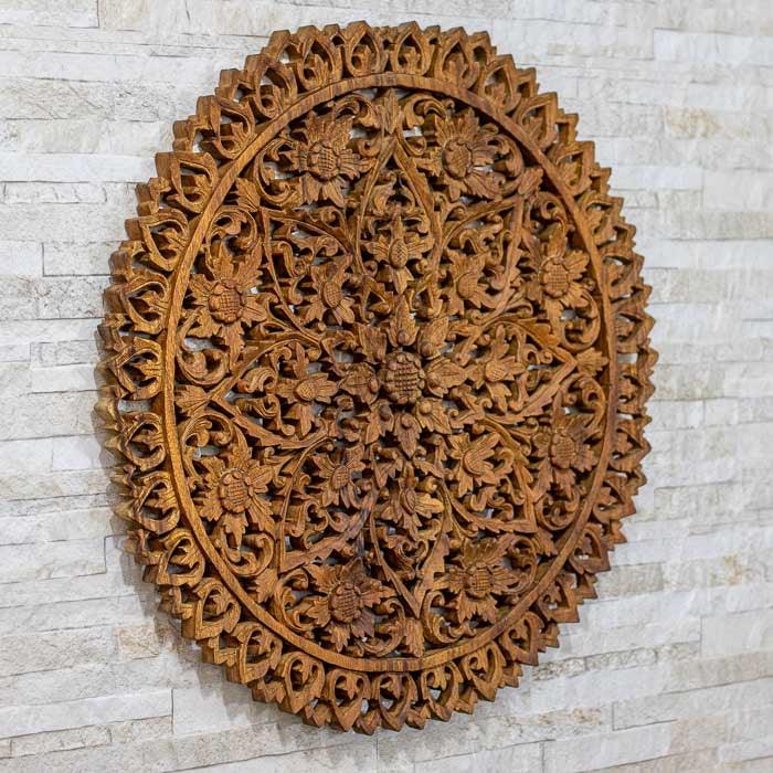 Objeto decorativo redondo com padrão floral boho, feito em madeira da Indonésia.