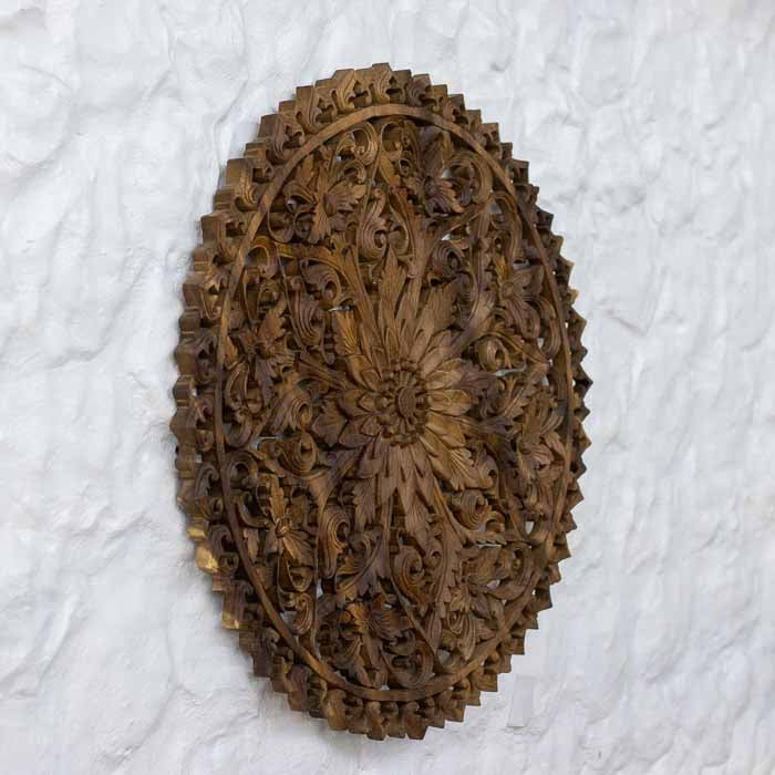 Objeto decorativo redondo com padrão floral boho, feito em madeira da Indonésia.