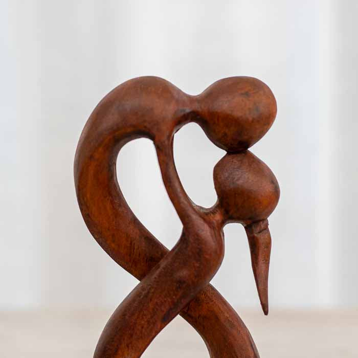 Estátua artesanal abstrata de casal apaixonado em madeira natural de Bali simbolizando o amor infinito.