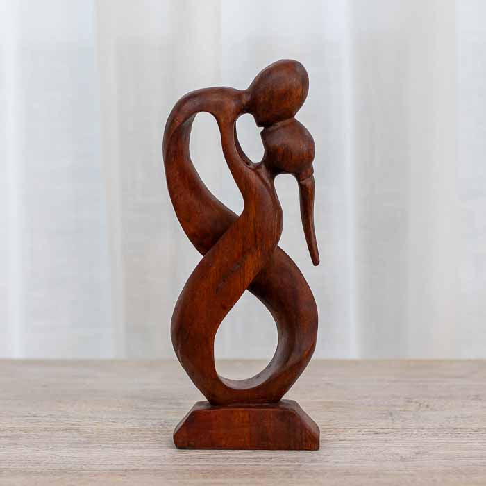 Arte decorativa balinesa: figuras de casal esculpidas em madeira com design orgânico.