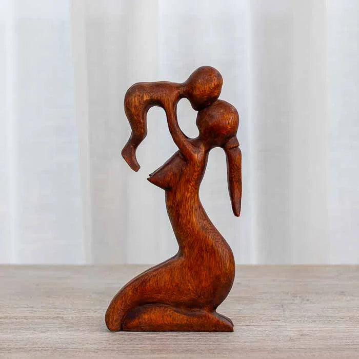 Detalhe da escultura artesanal de Bali simbolizando o amor materno e a proteção. 