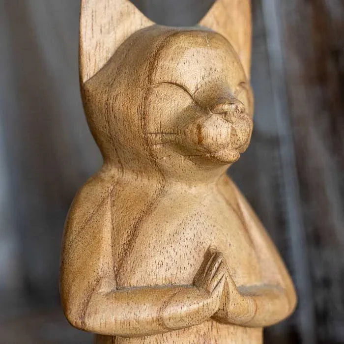 Escultura de gato com gesto Namastê feita à mão em madeira natural.