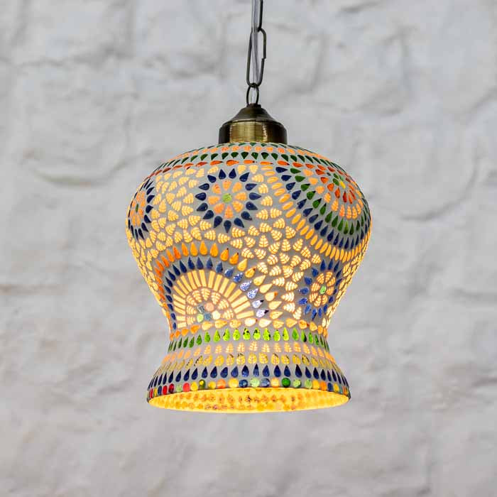 Composição de iluminação cênica com pendente de mosaico artesanal em ambiente aconchegante. 