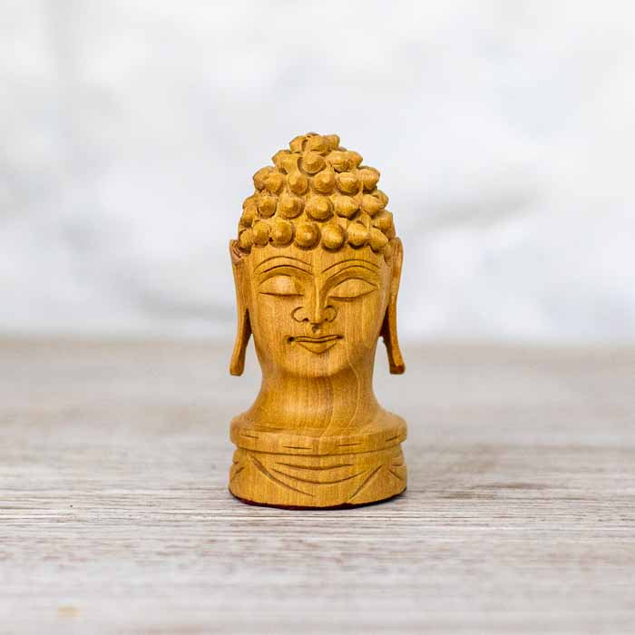 Detalhe da escultura de Cabeça de Buda indiana com olhos fechados e expressão de paz.